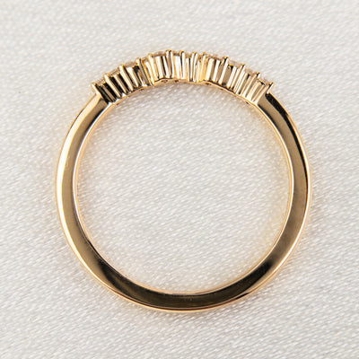An exquisite gold ring embellished with diamonds, reflecting a timeless elegance and opulence - resting on white material.