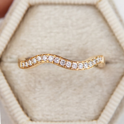 An exquisite 14k yellow gold band featuring pave set brilliant diamonds set in an elegant ring box, perfect for adding a touch of luxury to any occasion.