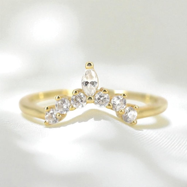 14k yellow gold wedding ring with diamonds contouring to a point on a soft white background.
