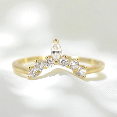 14k yellow gold wedding ring with diamonds contouring to a point on a soft white background.