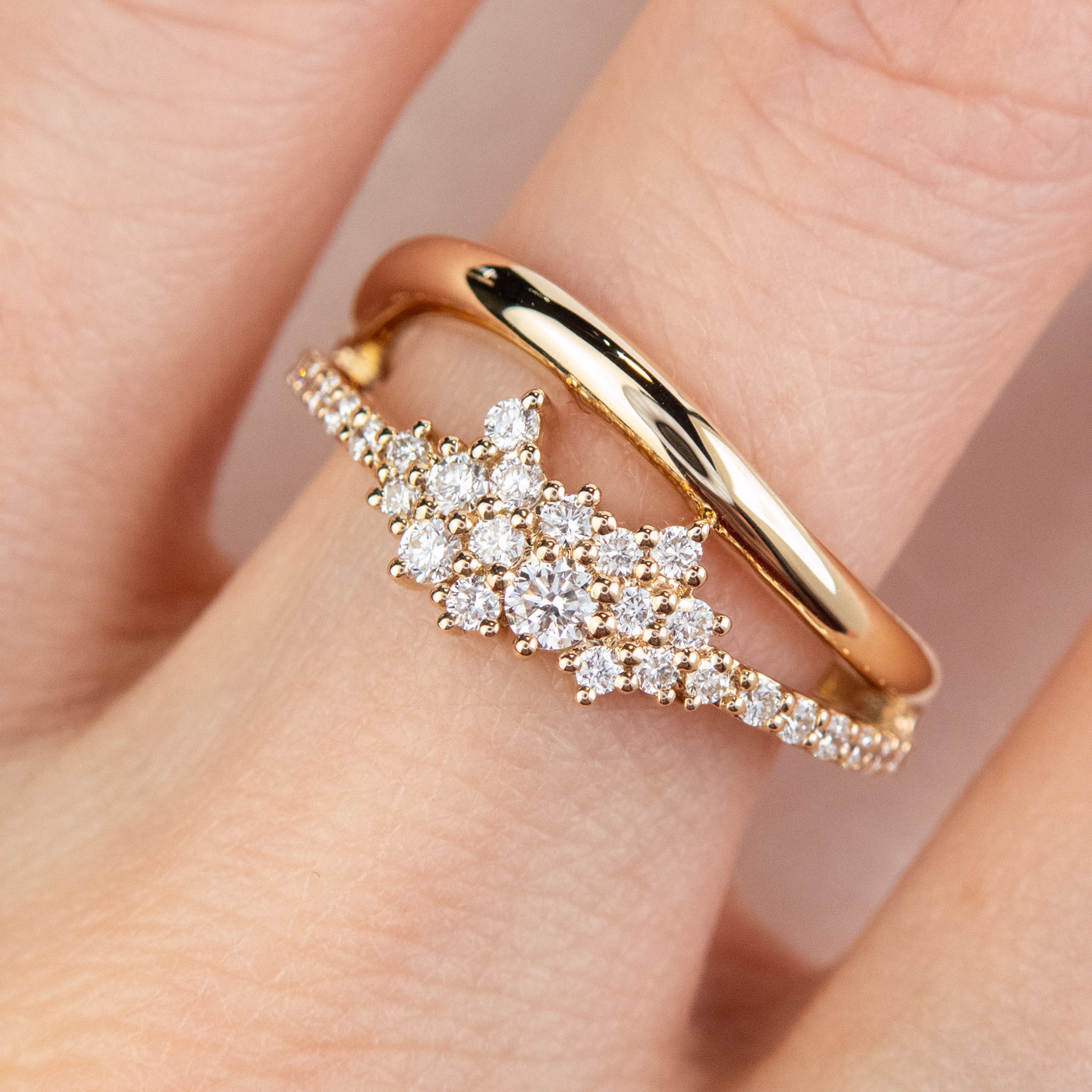 A beautiful gold ring featuring shimmering diamonds and a split band worn on a finger.