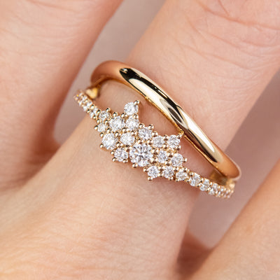 A beautiful gold ring featuring shimmering diamonds and a split band worn on a finger.
