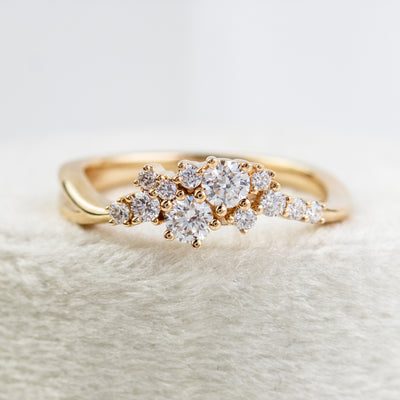 A stunning gold ring featuring a cluster of sparkling diamonds, set in a graduated design, elegantly showcasing its timeless beauty and craftsmanship.
