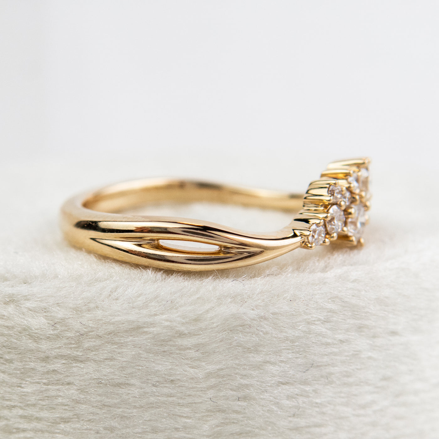 A stunning gold ring featuring a cluster of sparkling diamonds, set in a graduated design, elegantly showcasing its timeless beauty and craftsmanship.