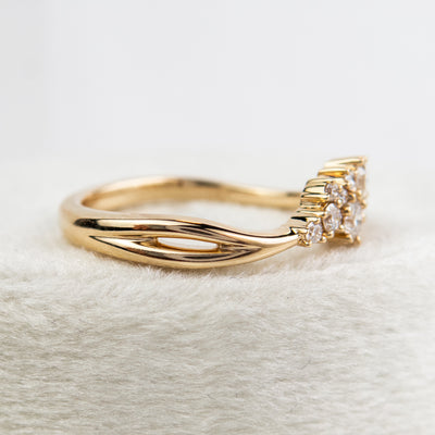 A stunning gold ring featuring a cluster of sparkling diamonds, set in a graduated design, elegantly showcasing its timeless beauty and craftsmanship.