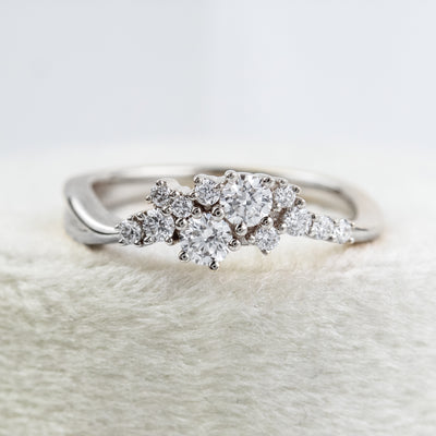 A stunning white gold ring featuring a cluster of sparkling diamonds, set in a graduated design, elegantly showcasing its timeless beauty and craftsmanship.
