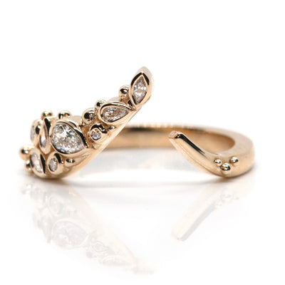 A delicate open gold ring featuring sparkling marquise, pear and round-cut diamonds set in an organic design, reflecting light beautifully.