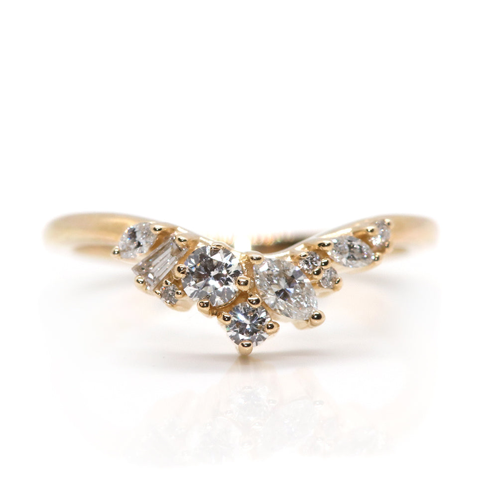 A delicate gold ring featuring an elegant arrangement of sparkling diamonds in various shapes, creating a stunning, unique design.