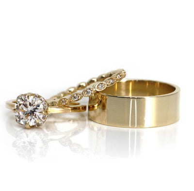 A 14KT solid gold unisex classic band  with a rectangular flat profile and smooth, flat interior stacked with a diamond engagement ring and diamond eternity band.