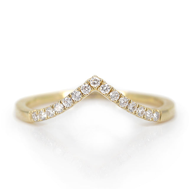 Elegant gold ring featuring a V-shaped or peak design adorned with sparkling diamonds along the band, reflecting light beautifully.