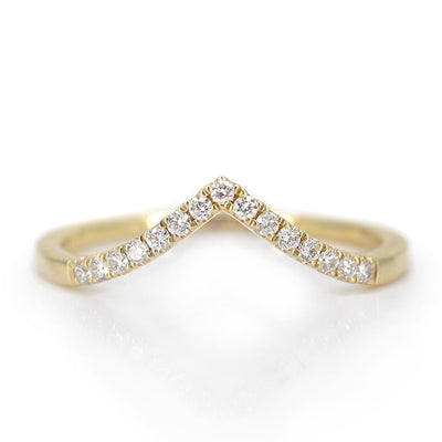 Elegant gold ring featuring a V-shaped or peak design adorned with sparkling diamonds along the band, reflecting light beautifully.