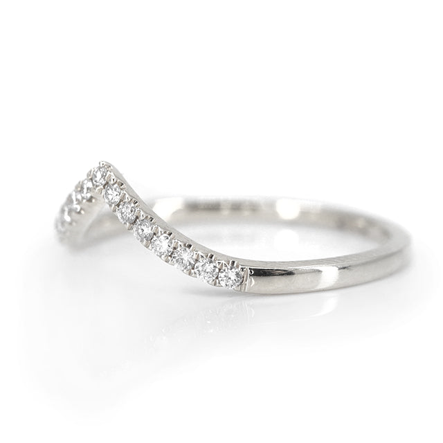 Elegant white gold ring featuring a V-shaped or peak design adorned with sparkling diamonds along the band, reflecting light beautifully shown from the side.