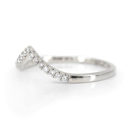 Elegant white gold ring featuring a V-shaped or peak design adorned with sparkling diamonds along the band, reflecting light beautifully shown from the side.