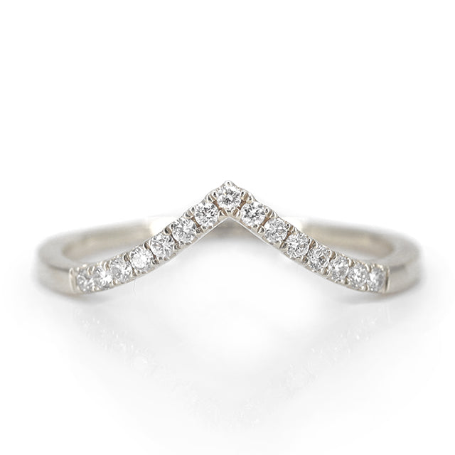 Elegant white gold ring featuring a V-shaped or peak design adorned with sparkling diamonds along the band, reflecting light beautifully.