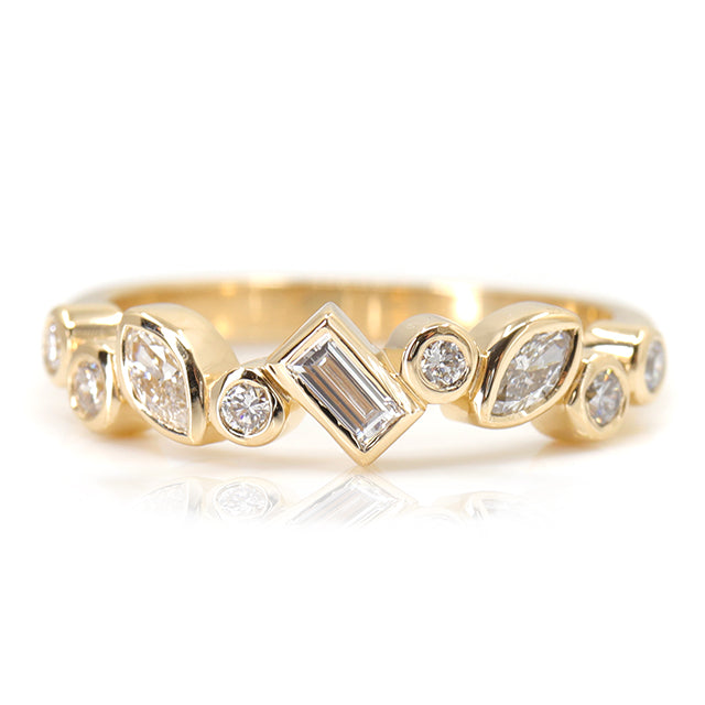 A stylish gold ring featuring assorted diamond shapes, including marquise, round emerald cut, set in a delicate bezel alternating design.