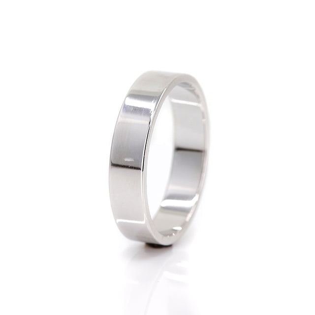 A white gold flat wedding band - elegant and simple shown on it's side.