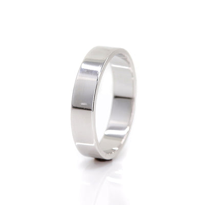 A white gold flat wedding band - elegant and simple shown on it's side.