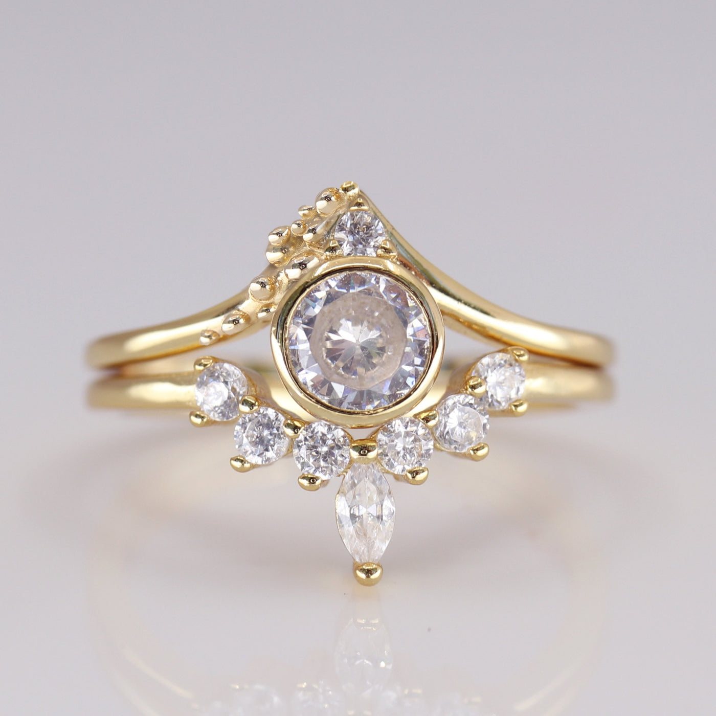 Elegant gold ring featuring a central round diamond surrounded by smaller stones and a marquise-shaped diamond, exuding vintage charm.