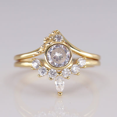 Elegant gold ring featuring a central round diamond surrounded by smaller stones and a marquise-shaped diamond, exuding vintage charm.