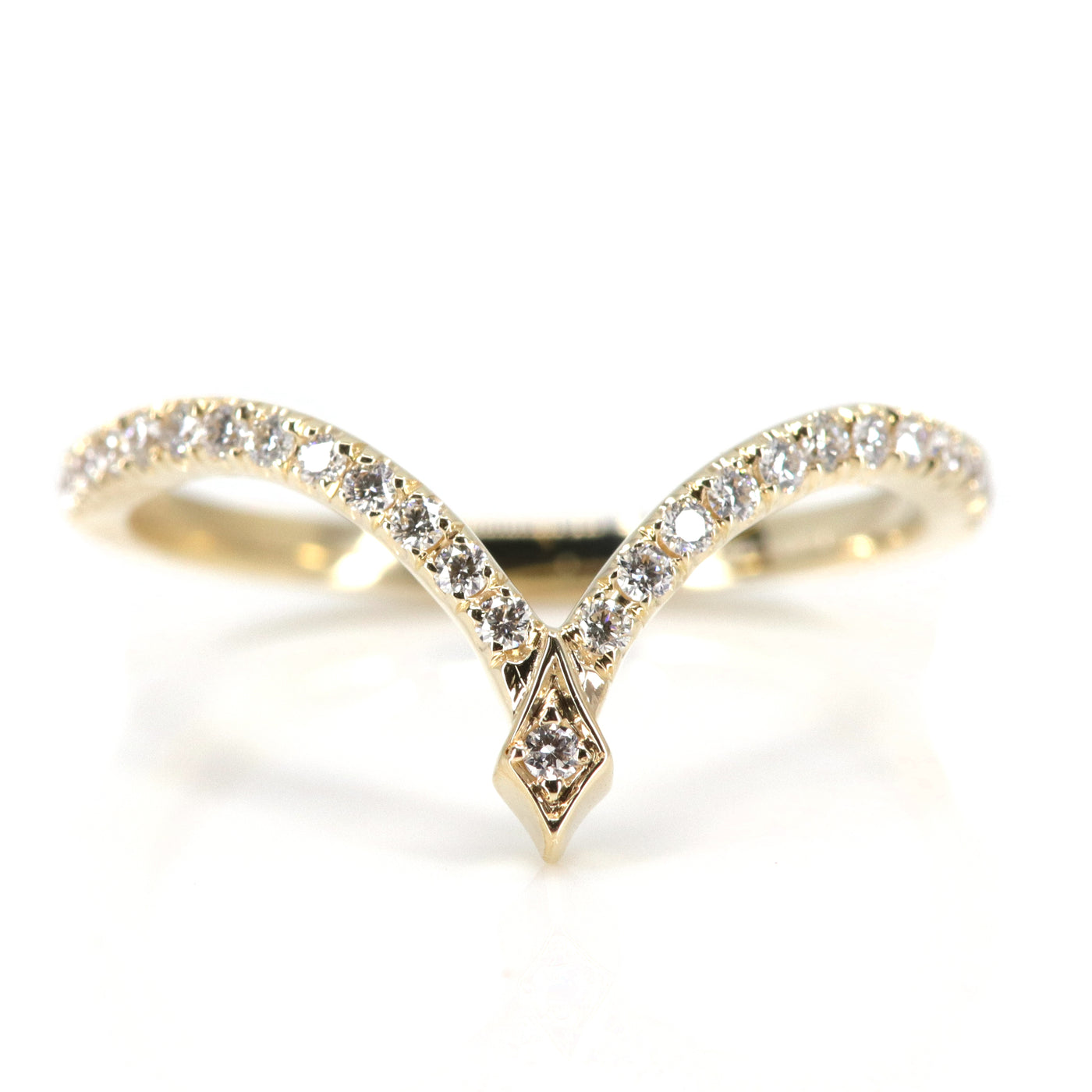 A delicate gold ring featuring a curved design adorned with sparkling diamonds, culminating in a stylish pointed apex.
