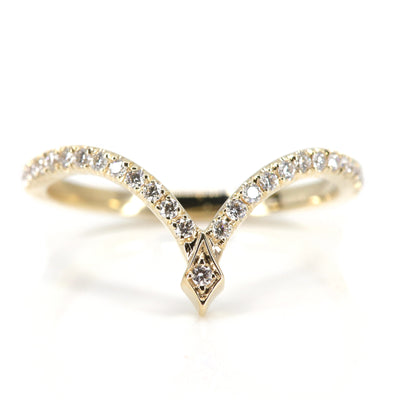 A delicate gold ring featuring a curved design adorned with sparkling diamonds, culminating in a stylish pointed apex.