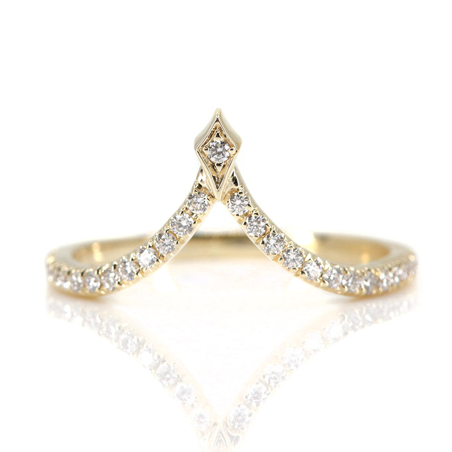 A delicate gold ring featuring a curved design adorned with sparkling diamonds, culminating in a stylish pointed apex.