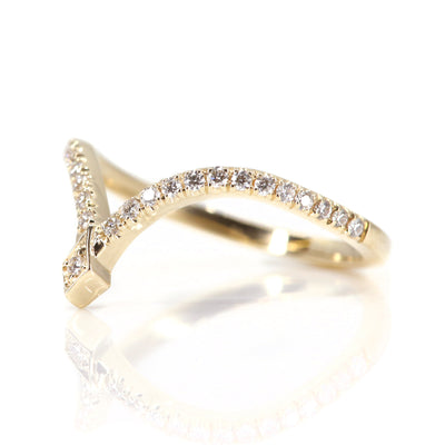 A delicate gold ring featuring a curved design adorned with sparkling diamonds, culminating in a stylish pointed apex shown from the side.