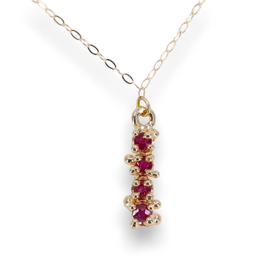 Ruby necklace in 14k yellow gold, shown on a white background