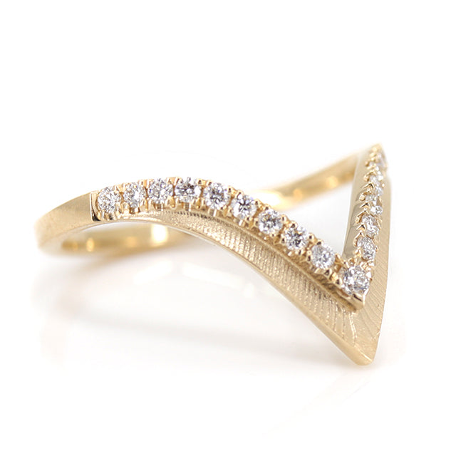 Elegant gold ring with a V-shaped design, encrusted with sparkling diamonds along the band shown upside down.