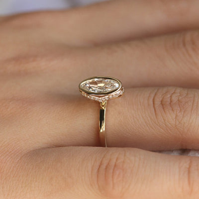 An elongated antique marquise-cut diamond ring bezel set with a polished gold band, sits elegantly on a hand.