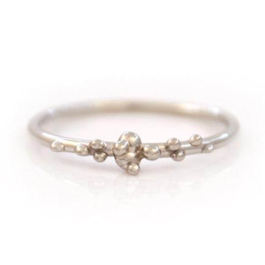 White gold stacking band with organic placed gold bubbles on a white background.