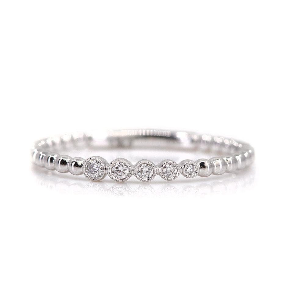 Elegant white gold ring featuring alternating shiny beads and five sparkling diamonds, set against a white background.