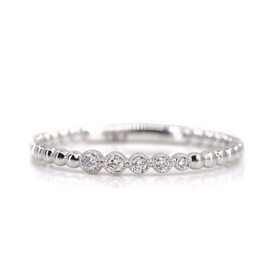 Elegant white gold ring featuring alternating shiny beads and five sparkling diamonds, set against a white background.