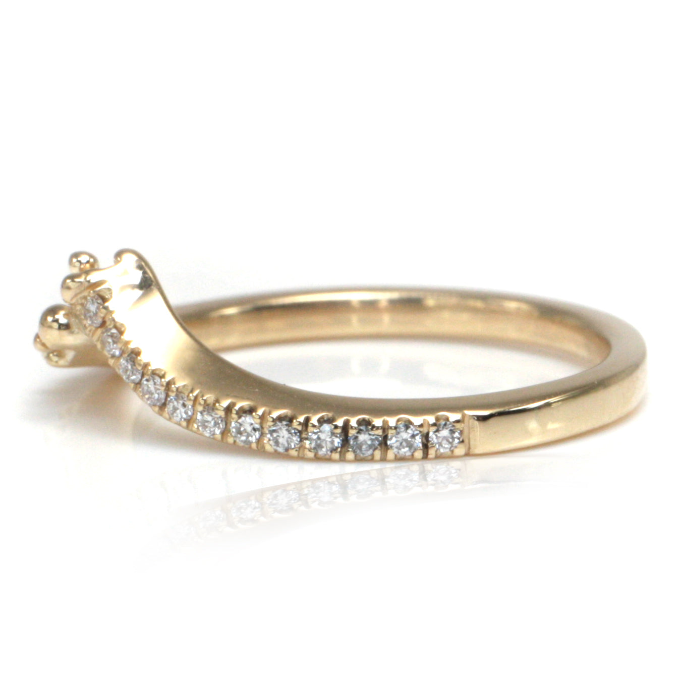 A delicate yellow gold ring featuring a curved design adorned with shimmering diamonds along one side and organically placed gold bubbles on the other shown from the side.