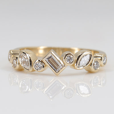 A stylish gold ring featuring assorted diamond shapes, including marquise, round emerald cut, set in a delicate bezel alternating design.