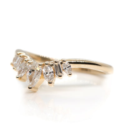 Peaked gold ring sparkles with 7 diamonds in oval, pear, marquise and rectangele shapes to form a crown appearance. Resting on a white background