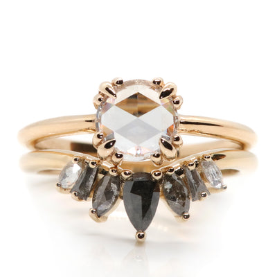 An elegant gold ring featuring a crown-like design with five diamonds in an ombre colour gradient, from black to salt & pepper to white diamonds stacked with a rosecut diamond solitaire ring.